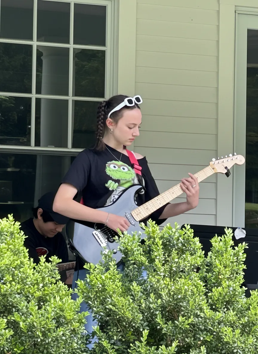 Student playing electric guitar outdoors