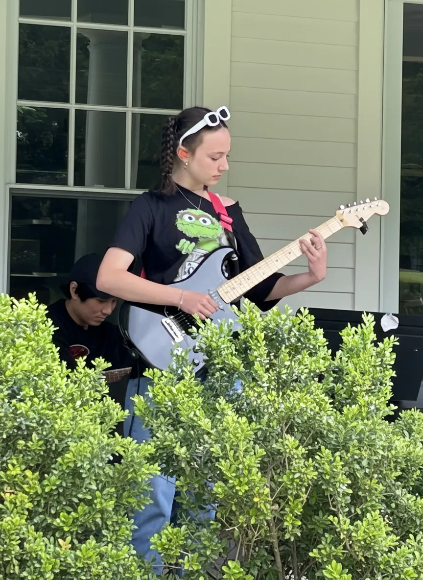 Student playing electric guitar outdoors